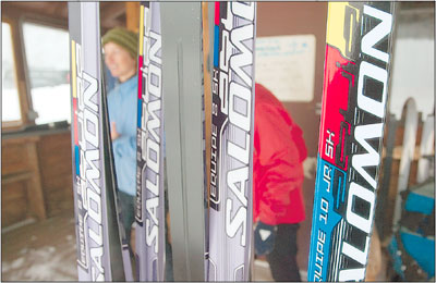 Skis stand waxed and waiting outside the Nordic Center on
Saturday morning as Helen Low, center director, watches the first
skiers of the year taking in some laps.