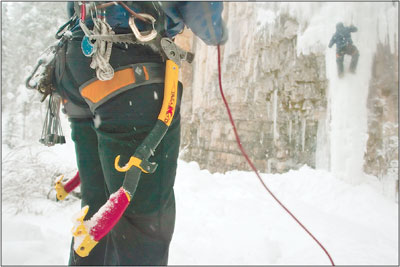 Climbing tools hang from the harness of Nate Dissler as he
belays local climber Andy Gibbs.