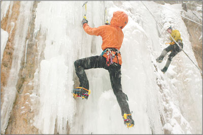 Jordan Griffler front points along a mixed route as another
climber is lowered to the snowy floor of the canyon