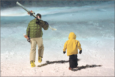 Eric Knutson, left, and son Finn forego the rope tow in favor of
making some hard-earned turns Monday evening.
