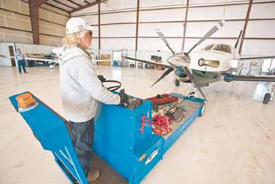 Jim Flory carefully pushes a plane back into the hangar for
storage.