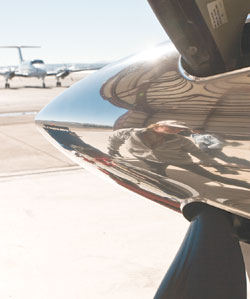 Jim Flory, reflected, pulls an aircraft from the hangar.