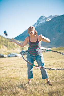 Stephanie Milner tosses a can into recycling while working a
hula-hoop in between shows on Saturday.