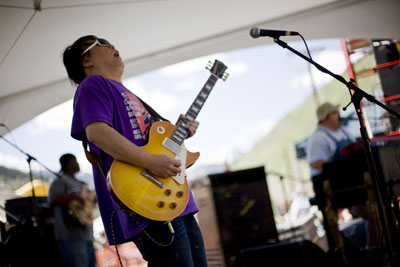 June Yamagashi, guitarist for Papa Grows Funk, bends a string on
his Les Paul during their high-energy set on Sunday.