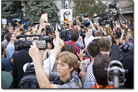 The media swarms over a confrontation during a rally just before
the march on Sunday.