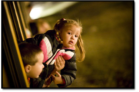 Kasi Montoya, held tightly by her father Andres, keeps an eye on
Santa as he boards the train at the North Pole.