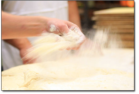 Flour is spread with a swift and agile flick of the wrist.