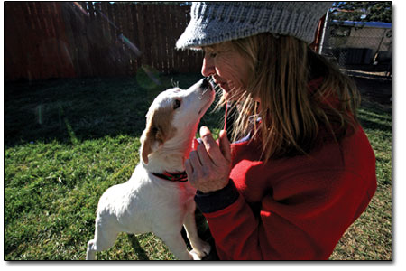 Volunteer Diane Zumer gives a little love to Titus, the pup.