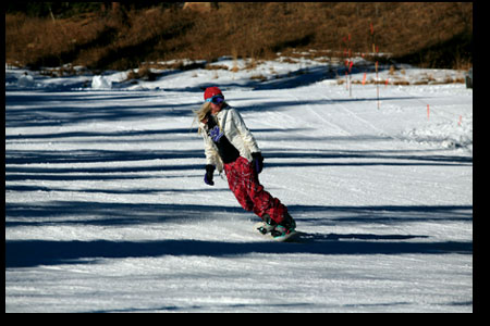 A snowboarder carves a few turns near the base of DMR.