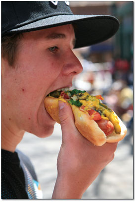 Jamie Finney scarfs down a fully loaded Chicago style hot dog,
courtesy of the Derailed Saloon.
