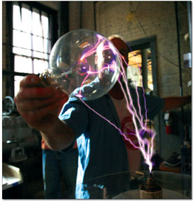 Smooth waves of electricity arc into an Edison Bulb.