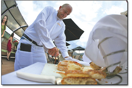 Waiter Jeff Sydow slices bread on Cosmopolitans swanky rooftop
patio.