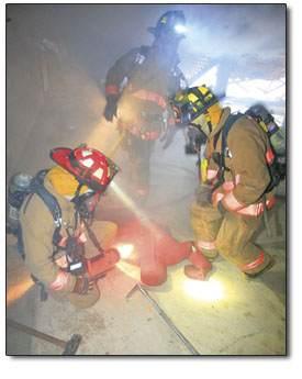 Rescuers come to the aid of a test dummy in a smoke-filled
room.