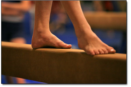 A gymnast carefully squares up for a practice run on the balance
beam.