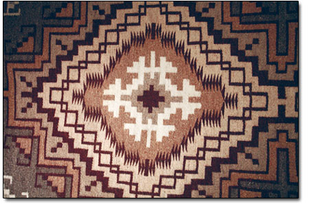 Perfect geometry and bright colors are typical characteristics
of Navajo Rug weavings. Shown here are a few expamples on display
at the Center.