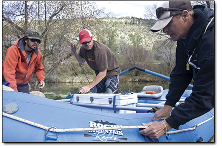 David Thuline, right, helps Steve Scheid, center, rig his brand
new raft while David Elwell watches on.